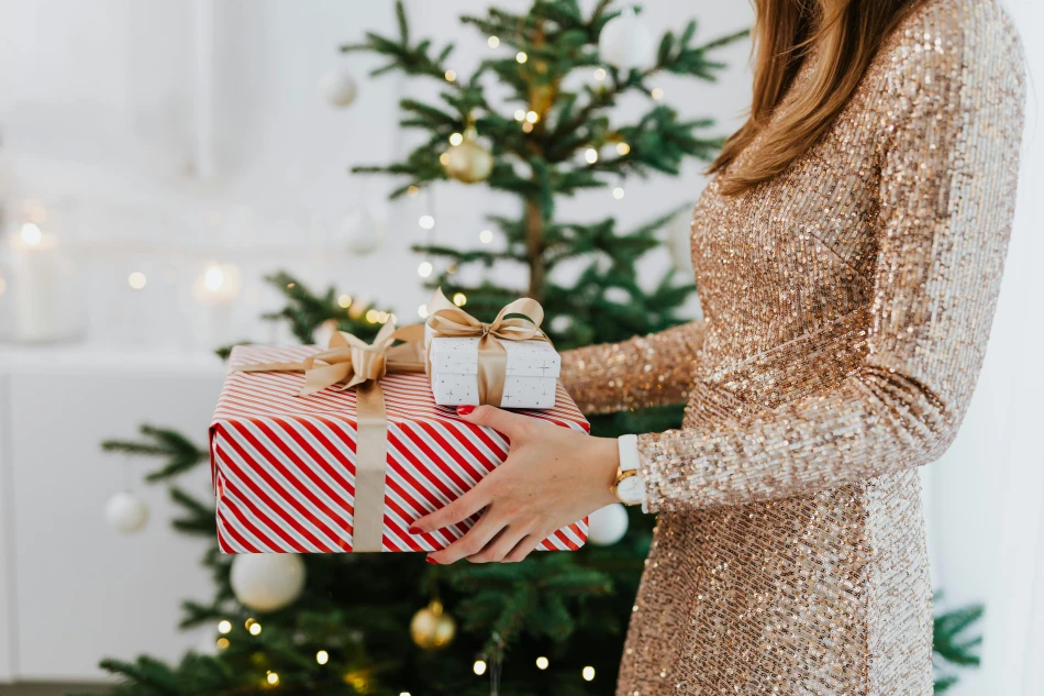 Woman in Golden Glittering Dress Holding Christmas Presents by Karola G via Pexels