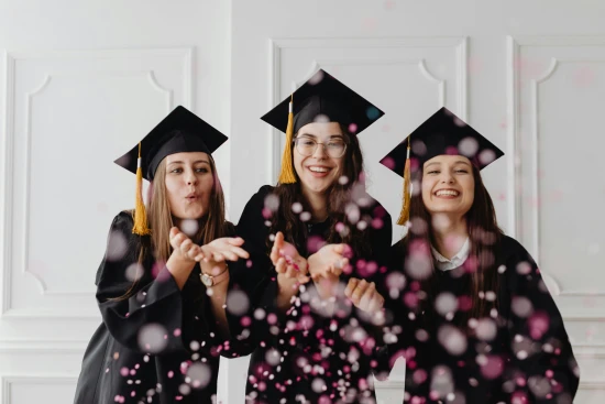 Women in Graduation Gowns and Caps Blowing Confetti by Photo by Kaboompics.com via Pexels