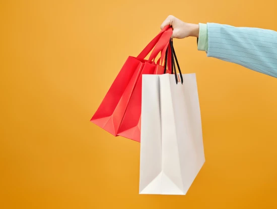 A person holding shopping bags, Photo by Max Fischer, Free to use under the Pexels License